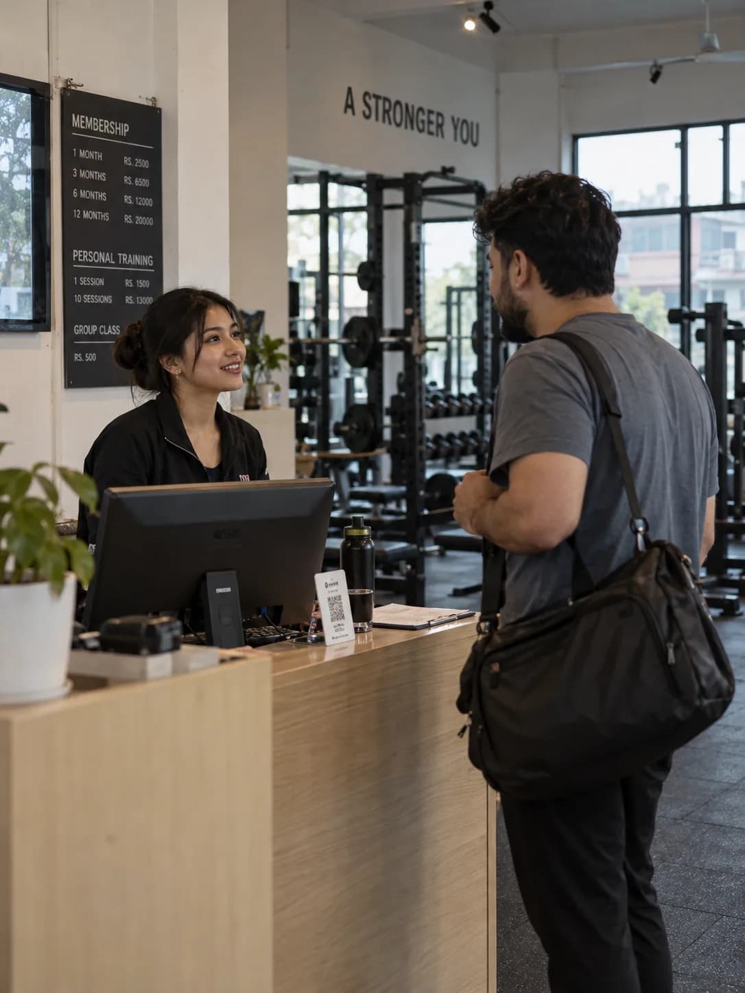A receptionist greets an early member at the front desk